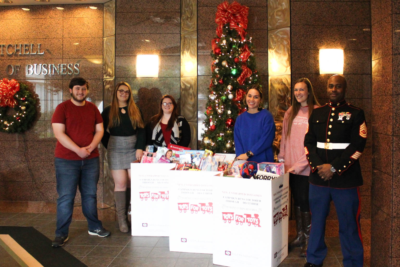 Students standing with toys collected for toys for tots.