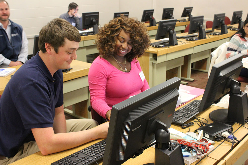 Students working in the tax assistance program at desks with computers.