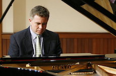 Seated at the Steinway piano on the Laidlaw stage is Dr. Robert Holm.