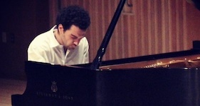 Pictured on stage during a rehearsal is a former participant in USA Piano Camps.