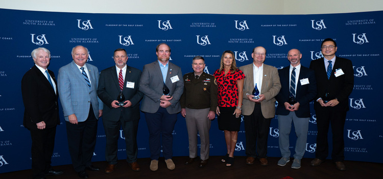 Pictured from left, Dr. Michael Chambers, interim vice president for research and economic development; USA President Jo Bonner, Dr. Todd McDonald, professor of computer science; Dr. Bret Webb, professor of civil, coastal and environmental sciences; Lt. General William J. Hartman, deputy commander of USCYBERCOM; Dr. Andi Kent, USA executive vice president and provost; Dr. Sean Powers, chair of the Stokes School of Marine and Environmental Sciences was representing Dr. Alison Robertson, associate professor of marine sciences; Dr. Tory Stevens, professor of physiology and cell biology; and Dr. Shenghua Wu, associate professor of civil, coastal and environmental engineering.