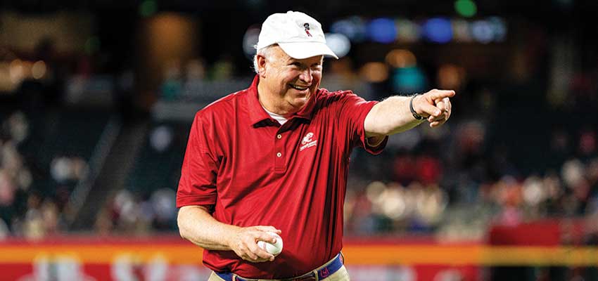 PRESIDENT JO BONNER throws the game’s ceremonial first pitch to Arizona Diamondbacks Hall of Famer and USA Trustee Luis Gonzalez during an alumni and friends event Aug. 13 at Chase Field.