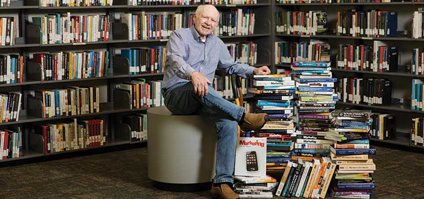 Dr. Joe Hair sitting with books around him.