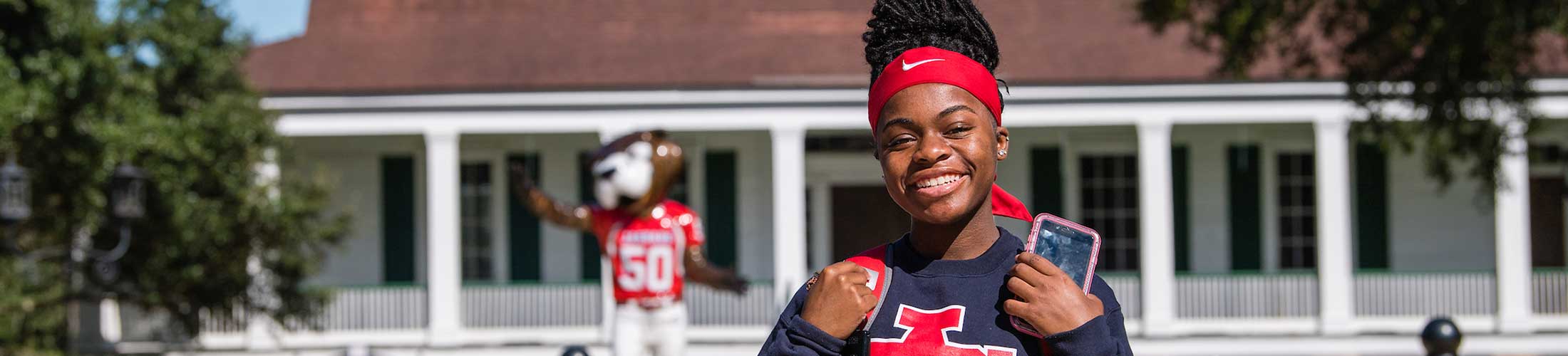 USA Student smiling in front of Southpaw Statue.