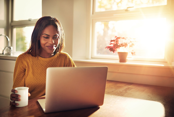 Woman drinking coffee at computer