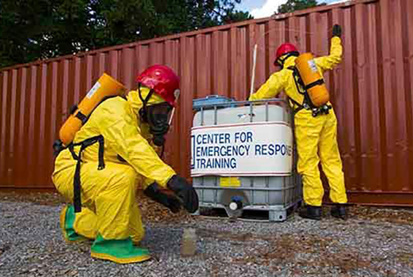 Two people in hazmat suits working at the center for emergency response training.