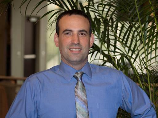 photo of Dr. David Meola standing in the Mitchell College of Business lobby