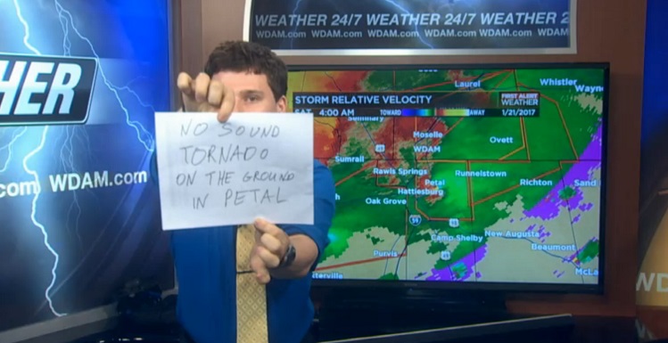Meteorologist Patrick Bigbie, a 2015 South graduate, used hand-made signs to warn viewers about severe weather when his sound was knocked out. 