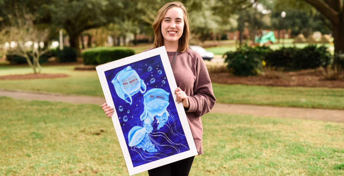 Grace Richardson, a University of South Alabama freshman from Hoover, holds a painting that was part of her Project Aquarius campaign. She earned the Girl Scouts' Gold Award as a result of her work. 