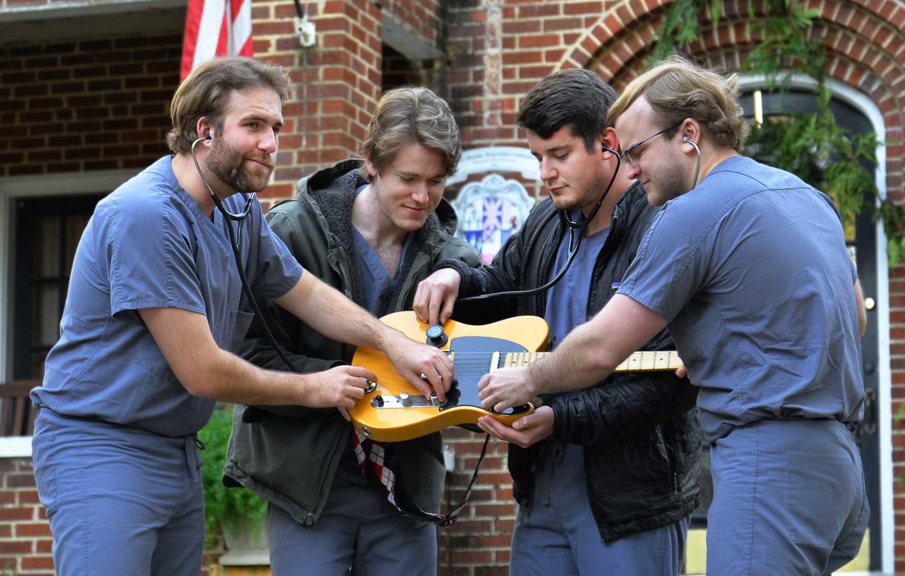 Members of the Grey Scrubs, one of five bands set to compete at the USA Health Doc Rock fundraiser on Jan. 30 at the Soul Kitchen in downtown Mobile. They are holding a guitar. 