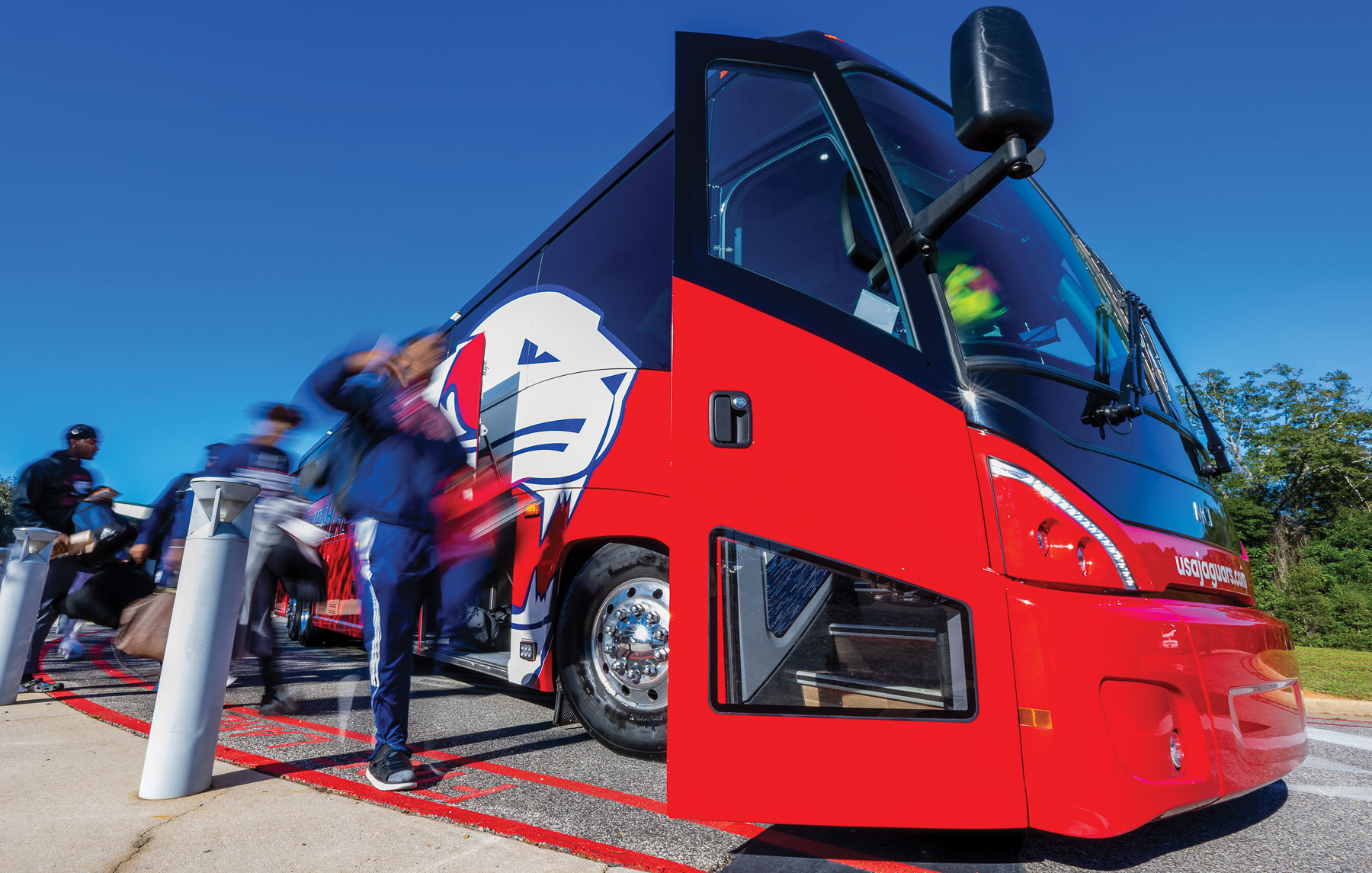 Four red and blue coach buses play an integral role in transporting University of South Alabama athletics teams. The buses are also used to transport high school students to campus for Jag Days tours. 