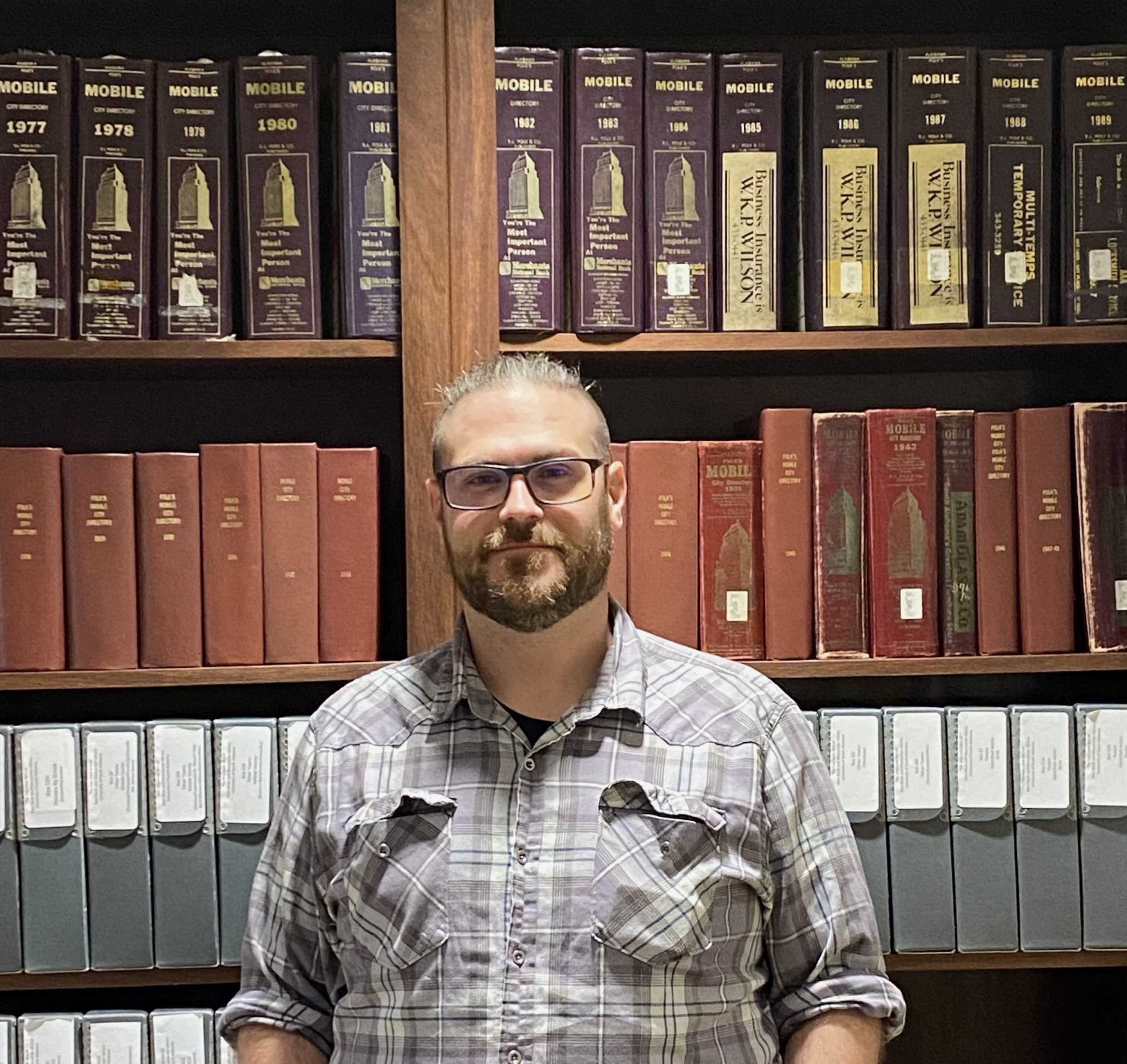 Daniel Shemwell is pictured standing in front of book cases in the McCall reading room.