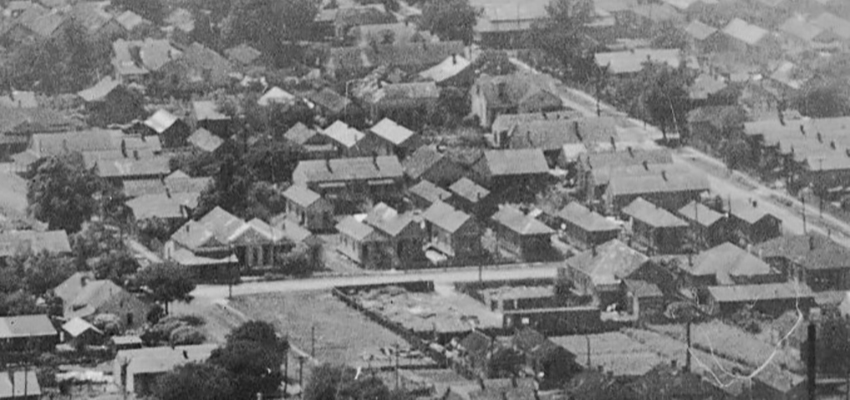 1922 aerial image showing dense housing along Our Alley between Texas and Elmira Streets. Houses can be seen directly behind the row of shotgun houses in the foreground. Image courtesy of the National Archives.