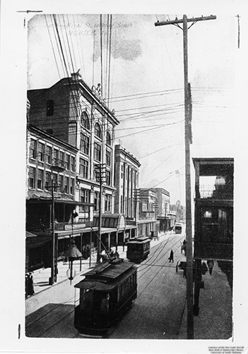 Black and white photo of two streetcars on a city street scene